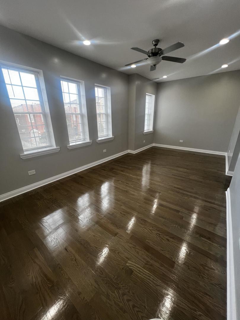 3257 West Warren Boulevard, Unit 2 Chicago, IL 60624 - Photo 3 of 21 a view of an empty room with window and wooden floor