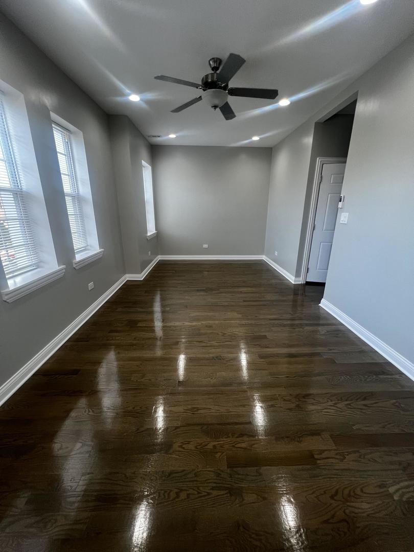 3257 West Warren Boulevard, Unit 2 Chicago, IL 60624 - Photo 4 of 21 a view of empty room with wooden floor and fan