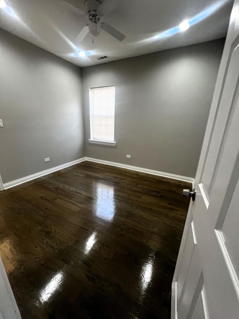 3257 West Warren Boulevard, Unit 2 Chicago, IL 60624 - Photo 5 of 21 an empty room with wooden floor and windows