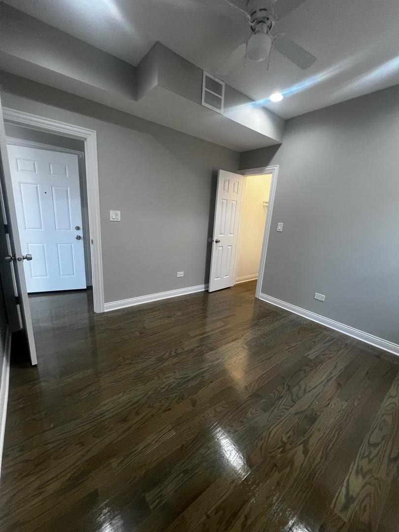 3257 West Warren Boulevard, Unit 2 Chicago, IL 60624 - Photo 6 of 21 an empty room with wooden floor and windows