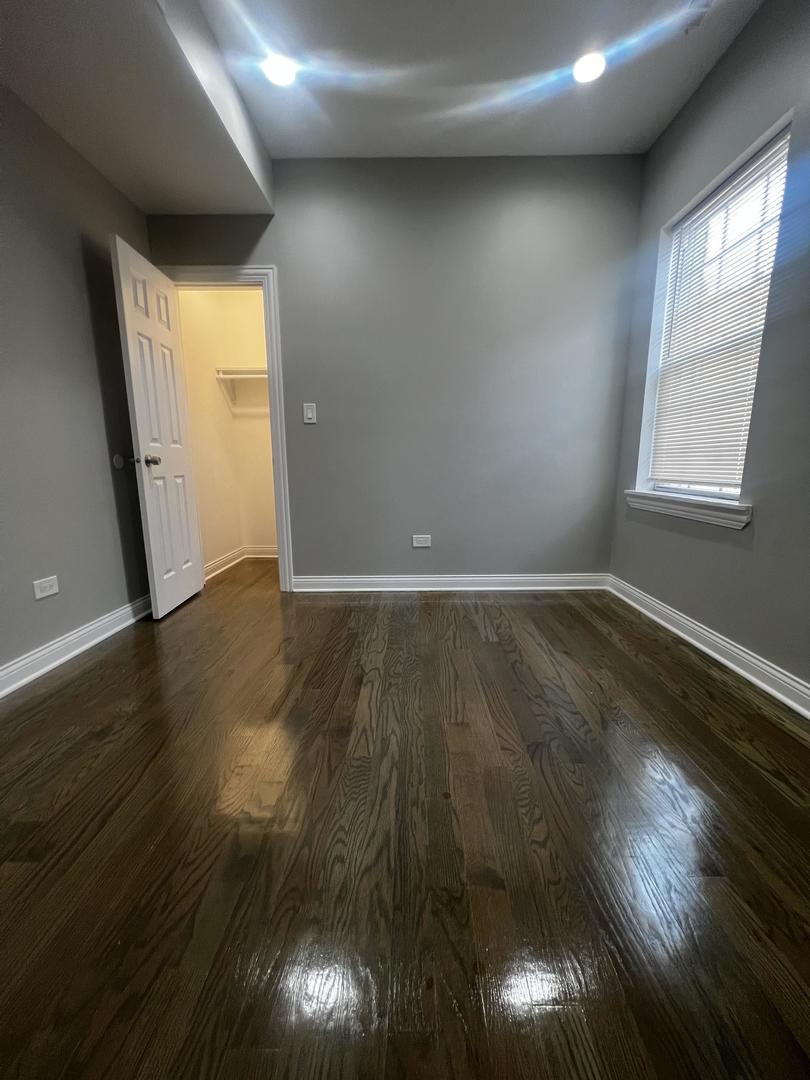 3257 West Warren Boulevard, Unit 2 Chicago, IL 60624 - Photo 7 of 21 an empty room with wooden floor and windows