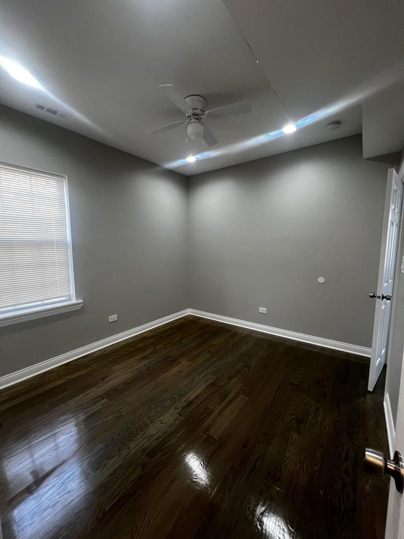 3257 West Warren Boulevard, Unit 2 Chicago, IL 60624 - Photo 8 of 21 an empty room with wooden floor and windows