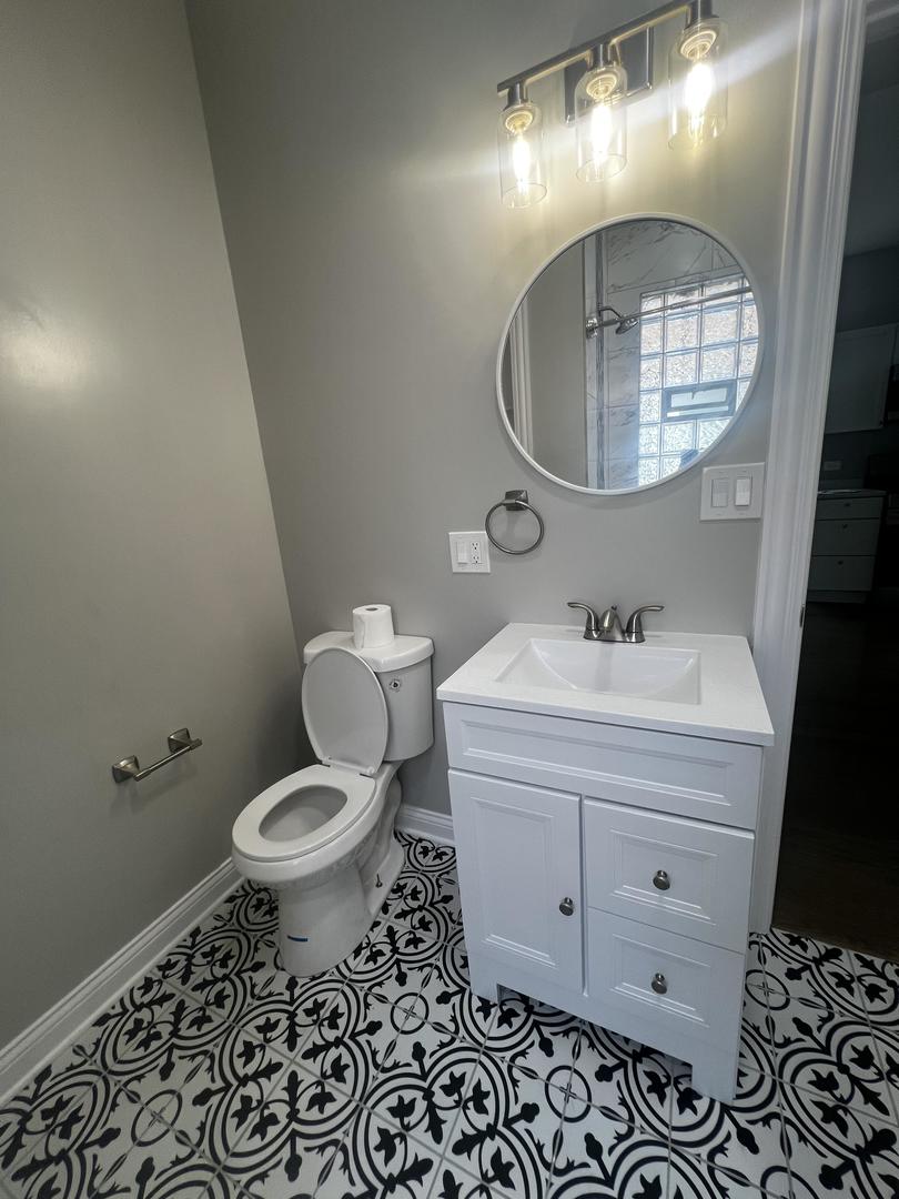 3257 West Warren Boulevard, Unit 2 Chicago, IL 60624 - Photo 10 of 21 a bathroom with a sink toilet and a mirror