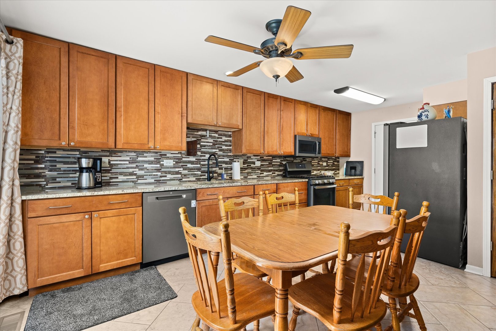 16830 South Parker Ridge Drive Lockport, IL 60441 - Photo 11 of 35 a kitchen with stainless steel appliances granite countertop a stove a sink dishwasher a refrigerator with a dining table and chairs