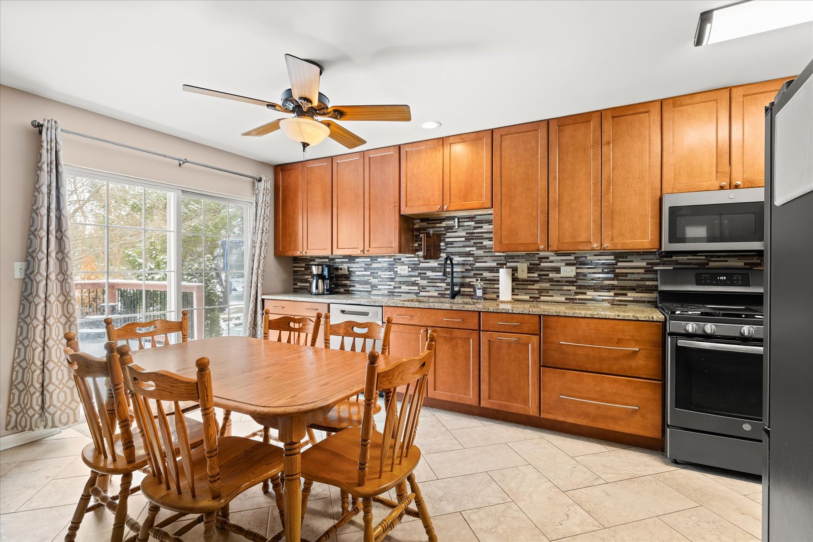16830 South Parker Ridge Drive Lockport, IL 60441 - Photo 9 of 35 a kitchen with stainless steel appliances granite countertop a stove a refrigerator a sink a dining table and chairs with wooden floor