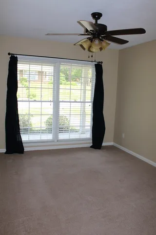 a view of a room with window a ceiling fan and a rug