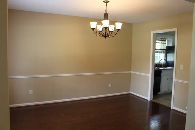 a view of a room with wooden floor and chandelier