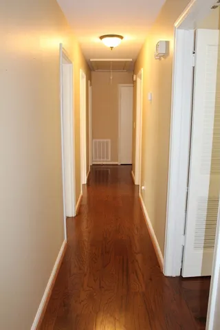a view of a hallway with wooden floor