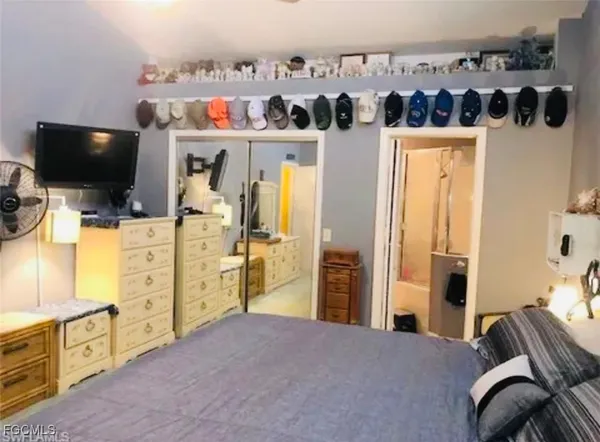 a view of a bedroom with workspace and windows