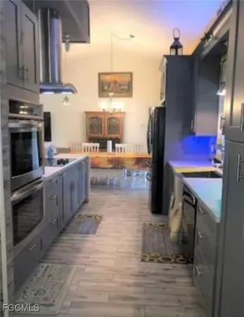 a kitchen with stainless steel appliances granite countertop a stove a refrigerator and a fireplace