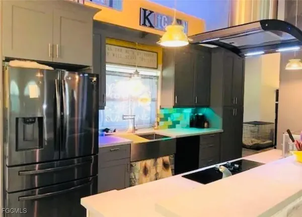 a kitchen with stainless steel appliances kitchen island granite countertop a refrigerator and a sink