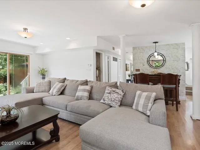 a living room with furniture a clock and a large window
