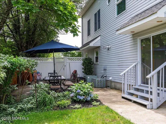 a view of a chair and table in backyard of the house