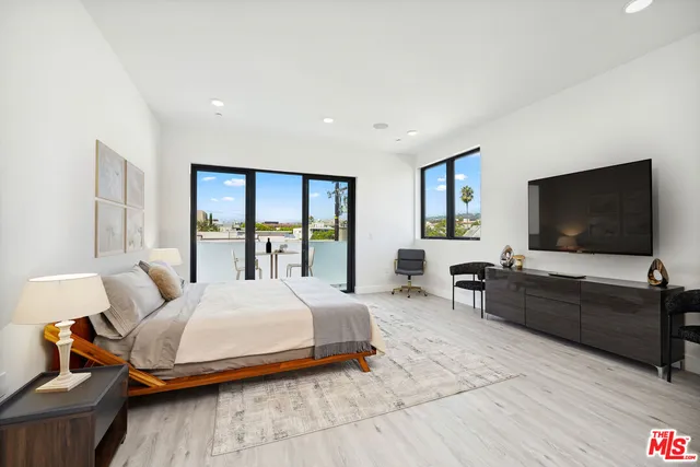 a bedroom with a bed and a flat screen tv