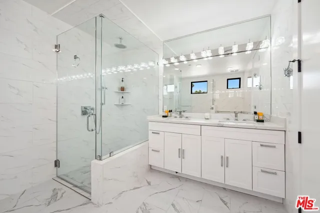 a spacious bathroom with a shower sink and mirror