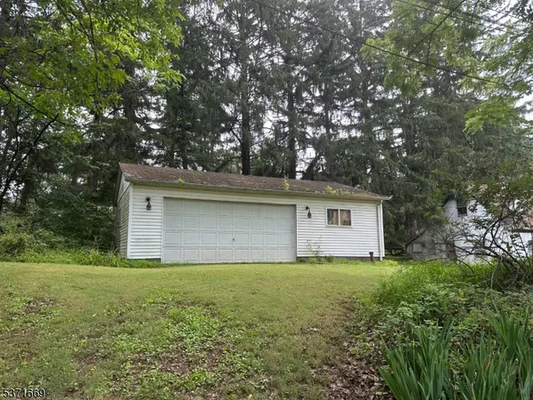 a white house that has tree in front of it