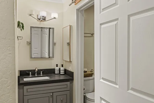 a bathroom with a sink vanity granite and a mirror