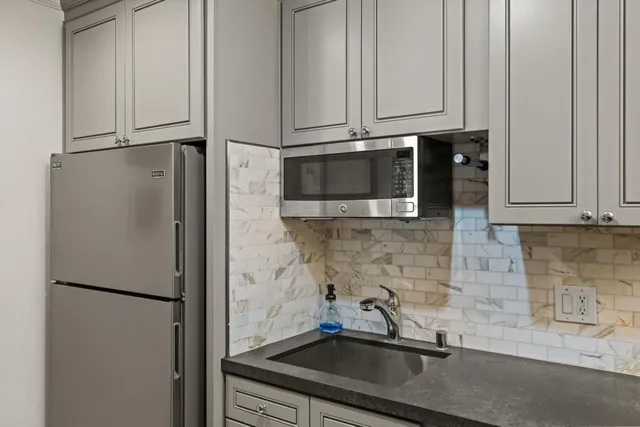 a kitchen with stainless steel appliances a refrigerator sink and cabinets