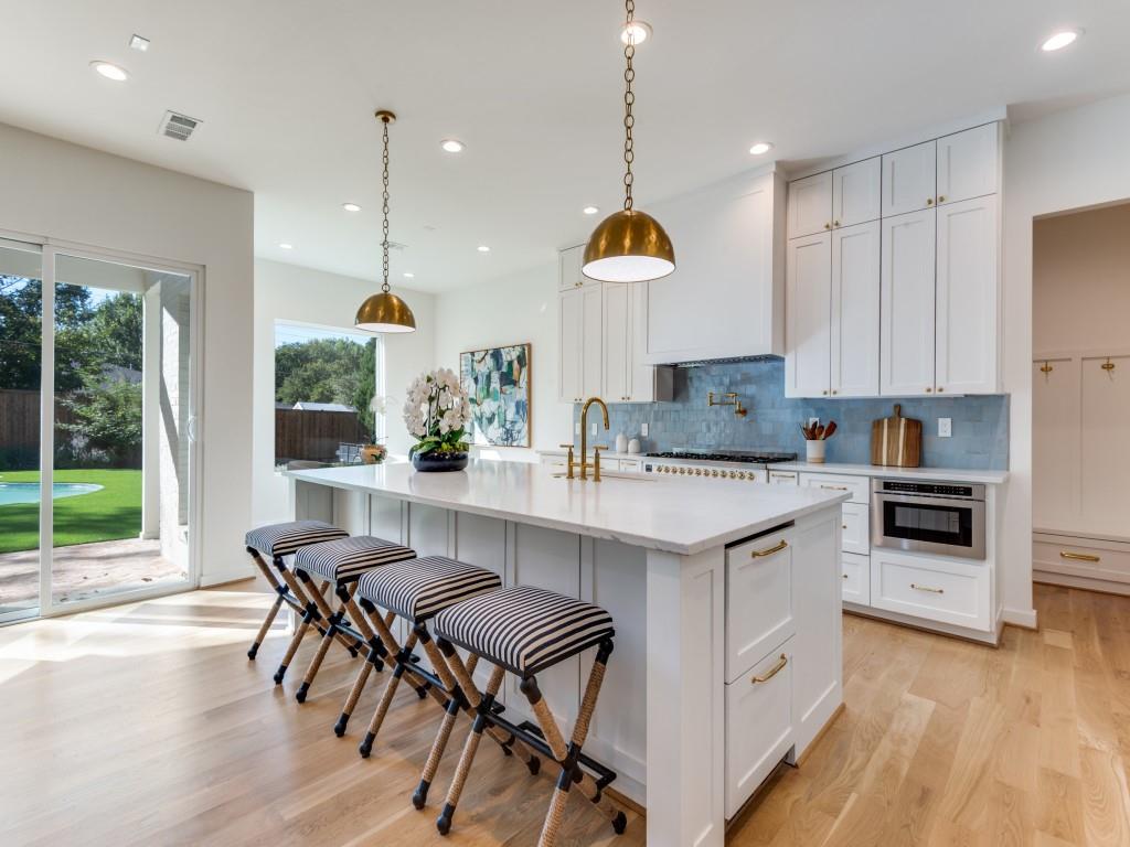 3838 Princess Lane Dallas, TX 75229 - Photo 4 of 26 a kitchen with granite countertop a stove a sink a dining table and chairs