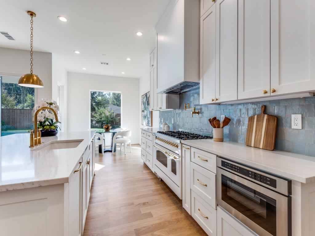 3838 Princess Lane Dallas, TX 75229 - Photo 5 of 26 a kitchen with stainless steel appliances granite countertop a stove a sink a refrigerator and white cabinets with wooden floor