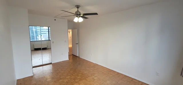 a view of an empty room with a chandelier fan