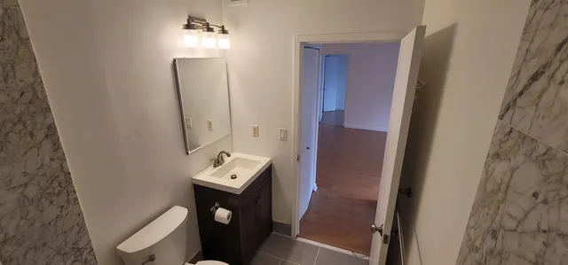 a bathroom with a toilet sink and mirror
