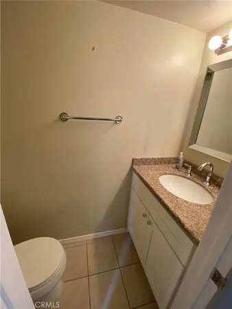 a bathroom with a granite countertop sink toilet and a mirror