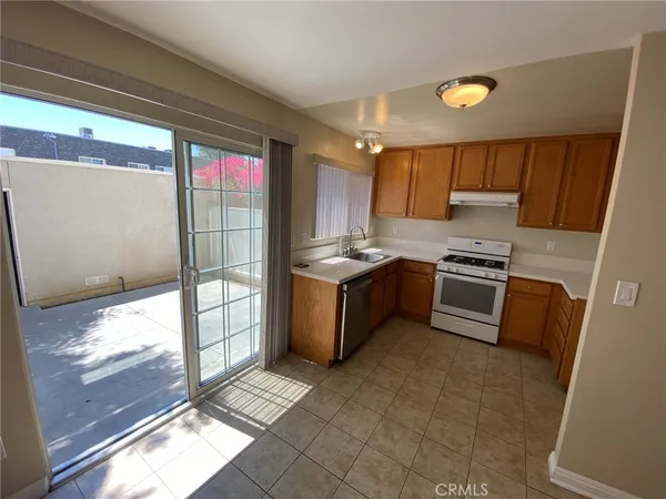 a kitchen with granite countertop a stove a sink and a refrigerator