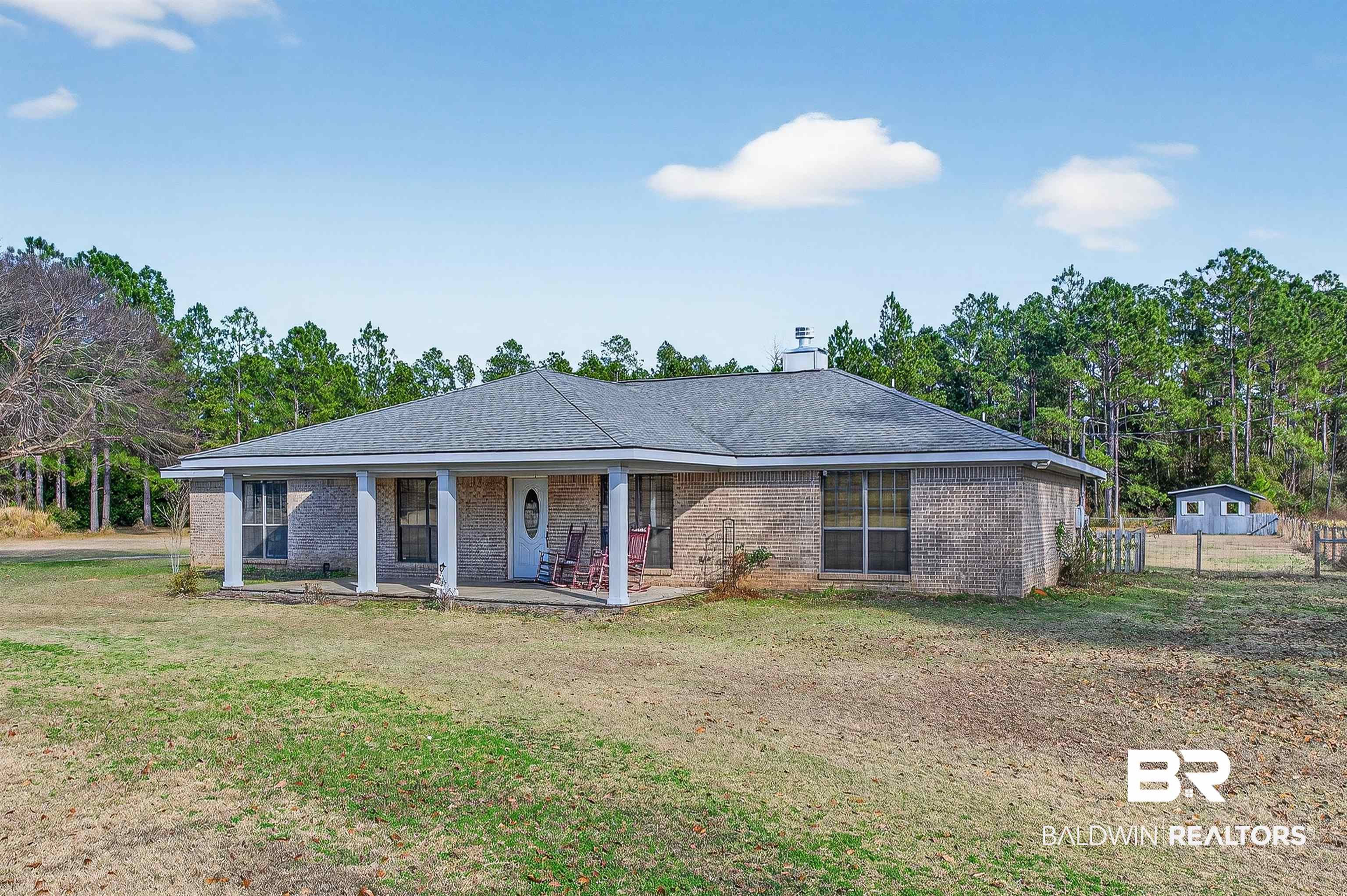 29635 Gardner Road Elberta, AL 36530 - Photo 64 of 66 Ranch-style house with brick siding, covered porch, roof with shingles, a chimney, and view of wooded area