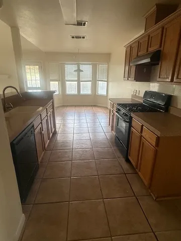 a kitchen with stainless steel appliances granite countertop a stove a sink a microwave a counter top space and cabinets