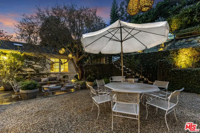 a view of a patio with table and chairs under an umbrella