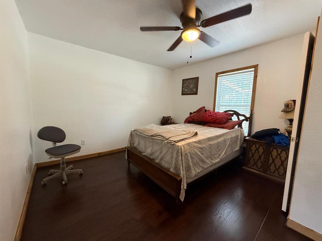 900 North Tiffin Road Ranger, TX 76470 - Photo 26 of 33 a bedroom with a bed and a chandelier