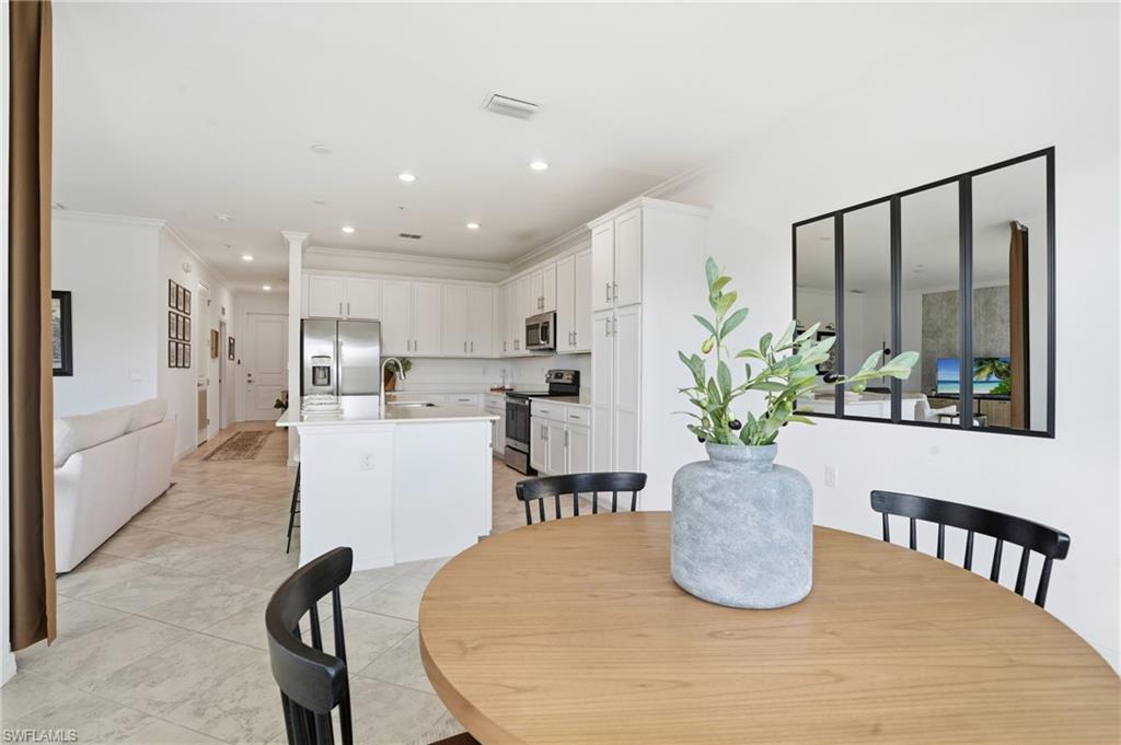6046 National Boulevard, Unit 446 Immokalee, FL 34142 - Photo 12 of 50 a dining room with furniture a potted plant and kitchen view