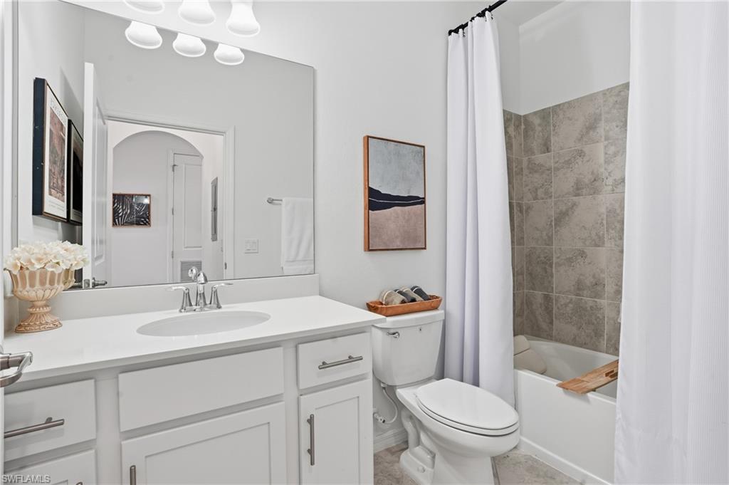 6046 National Boulevard, Unit 446 Immokalee, FL 34142 - Photo 19 of 50 a bathroom with a sink a toilet a mirror a vanity and shower