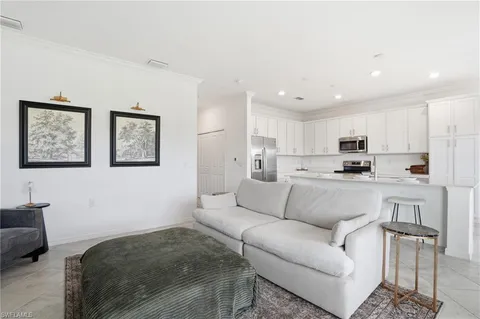 a living room with furniture and kitchen view