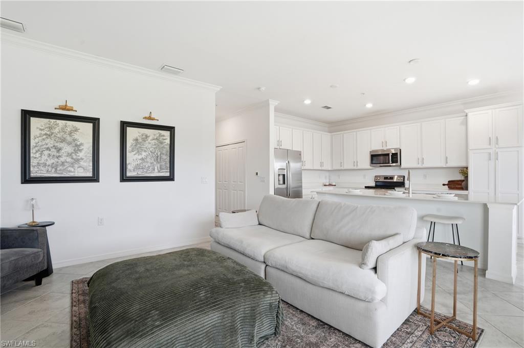 6046 National Boulevard, Unit 446 Immokalee, FL 34142 - Photo 8 of 50 a living room with furniture and kitchen view