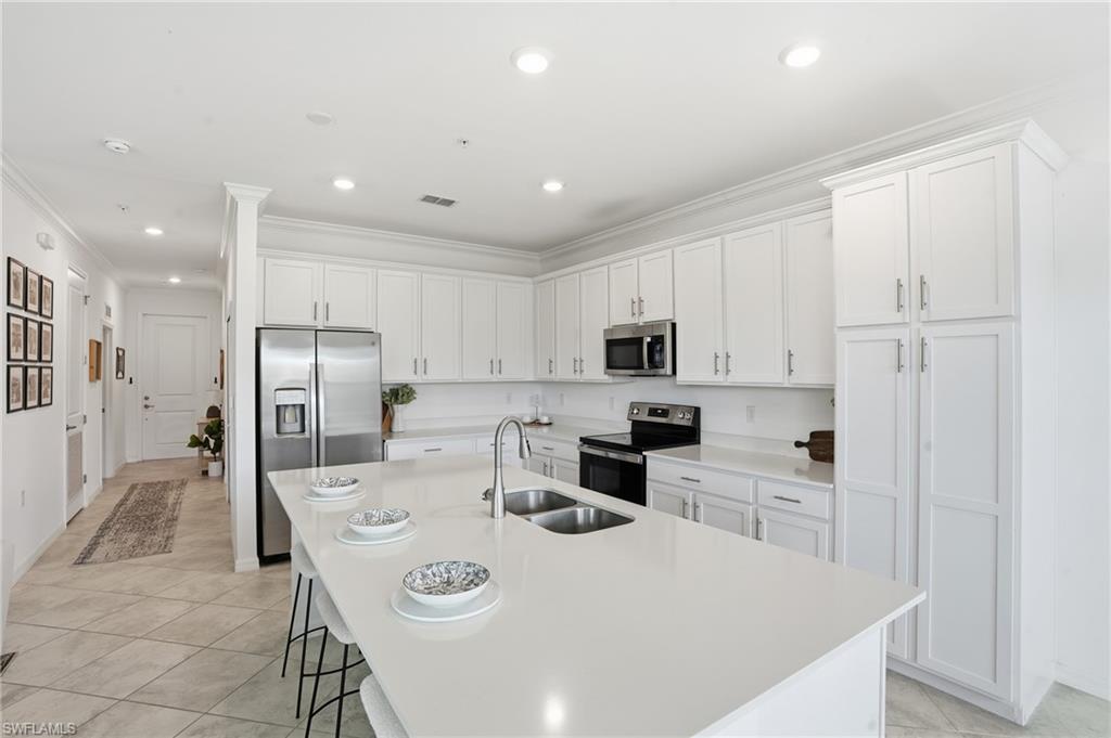 6046 National Boulevard, Unit 446 Immokalee, FL 34142 - Photo 9 of 50 a kitchen with stainless steel appliances a refrigerator stove microwave and cabinets