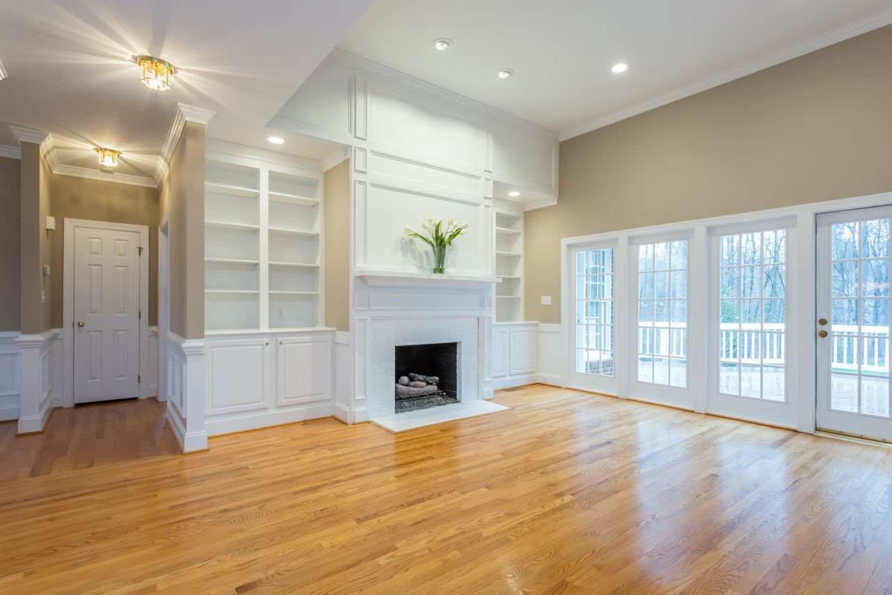 8704 Carriage Tour Lane Raleigh, NC 27615 - Photo 8 of 25 Feel the warmth from the fireplace flanked with bookcases as you look out over the deck to a beautifully landscaped backyard with lovely roses and hardwoods. Family Room