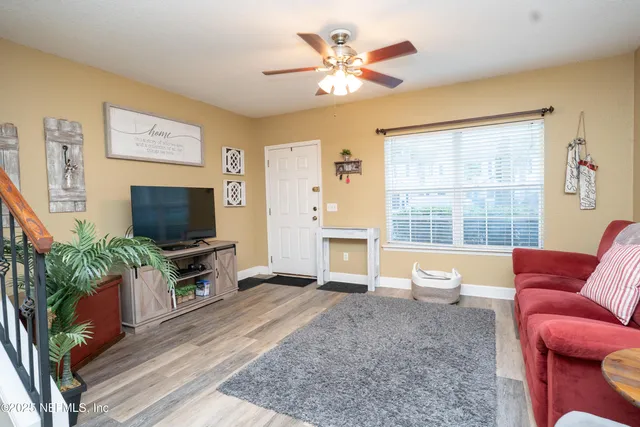 a living room with furniture a flat screen tv and a large window