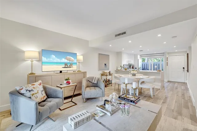 a living room with furniture and a dining table with wooden floor