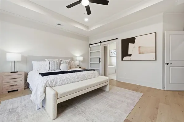 a bedroom with a bed chandelier and a window