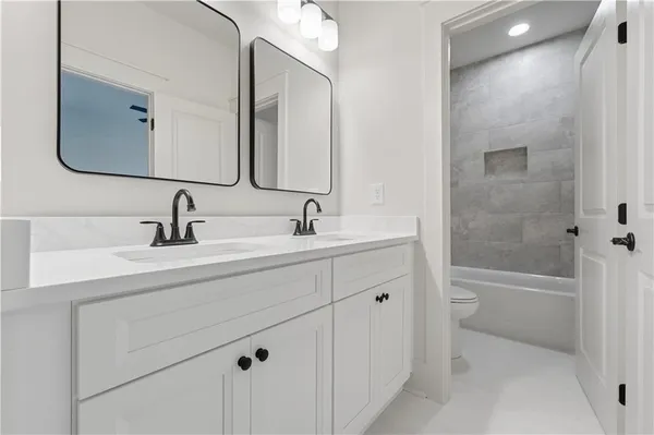 a bathroom with a double vanity sink mirror and bathtub