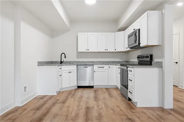 a kitchen with granite countertop white cabinets and white appliances