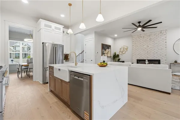 a kitchen with kitchen island a counter top space a sink stainless steel appliances and cabinets