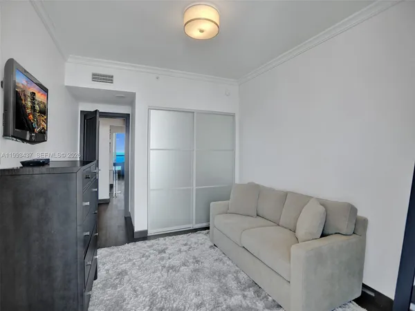 a bedroom with a bed and a painting on the wall