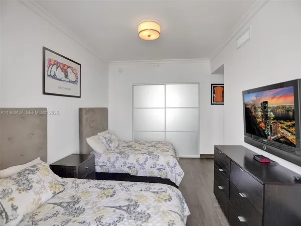 a bedroom with a bed and a television