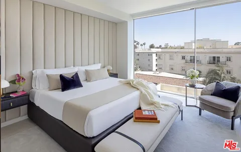 a bedroom with a bed and a couch next to a window