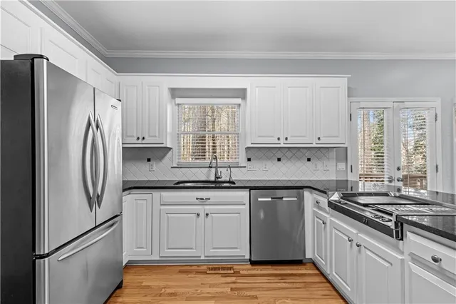 a kitchen with stainless steel appliances granite countertop a refrigerator stove sink and cabinets