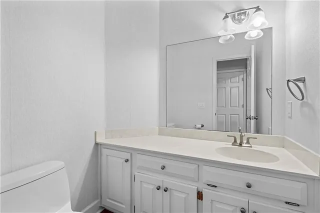 a bathroom with a sink vanity and toilet