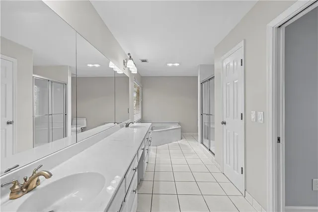 a spacious bathroom with a double vanity sink and a mirror